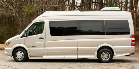 Side view of a beige Roadtrek E-trek rv rental van, equipped for comfortable travel.