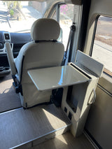 An rv rental's interior: passenger seat swiveled to face a compact table and side console with power outlets for convenience.