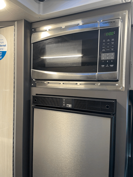 A Contoure microwave and Norcold refrigerator integrated into an rv rental, showcasing compact kitchen appliances for efficient living.