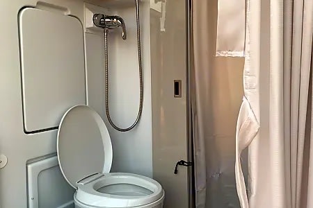  and outdoor views. Perfect for your campervan road trip cooking.|RV rental interior with a compact kitchen — photo 9