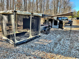 Compact rv rental: a teardrop camper trailer with an attached screen room and awning, on gravel, by a Jeep.