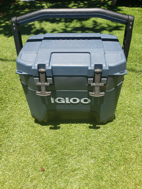Rugged gray Igloo cooler on green grass, ideal for an RV rental. Features sturdy handle & latches.