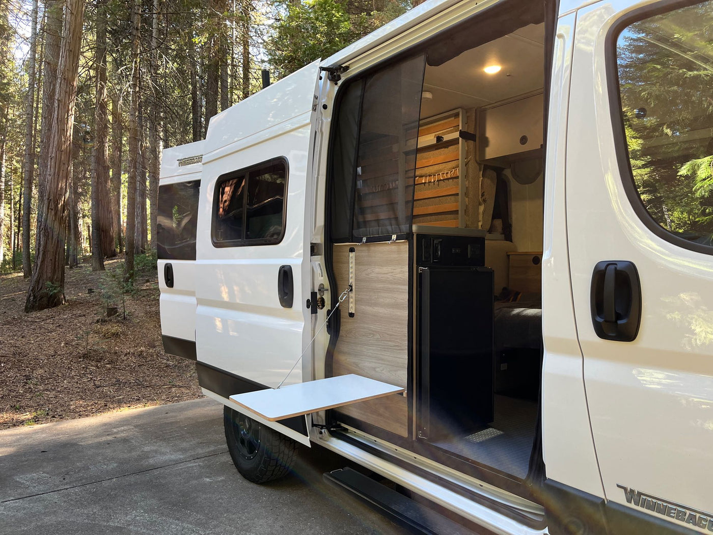  with a person walking. Ideal for outdoor travel.|Discover freedom with this RV rental. White camper van in a sunny forest — photo 2