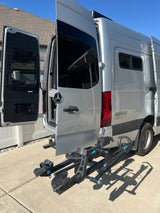 Silver Winnebago Sprinter RV rental camper van with open rear doors and a bike rack, ready for adventure.