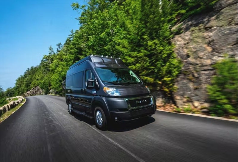  and scooter. Perfect for an RV rental beach adventure under a clear sky.|Dark grey Ram ProMaster RV rental on a scenic coastal road with ocean views.|Dark gray Ram ProMaster camper van — photo 6