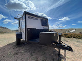TigerMoth camper trailer, perfect for your next rv rental adventure, parked in a sunny, rugged landscape.