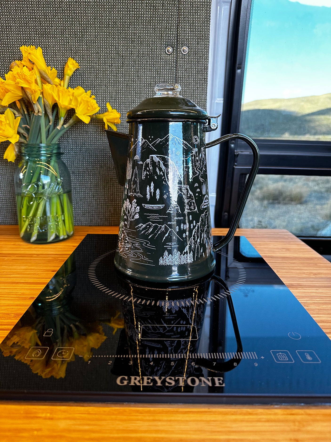 RV rental kitchen: Dark green coffee percolator on a Greystone induction cooktop, with fresh daffodils. Perfect for travel!