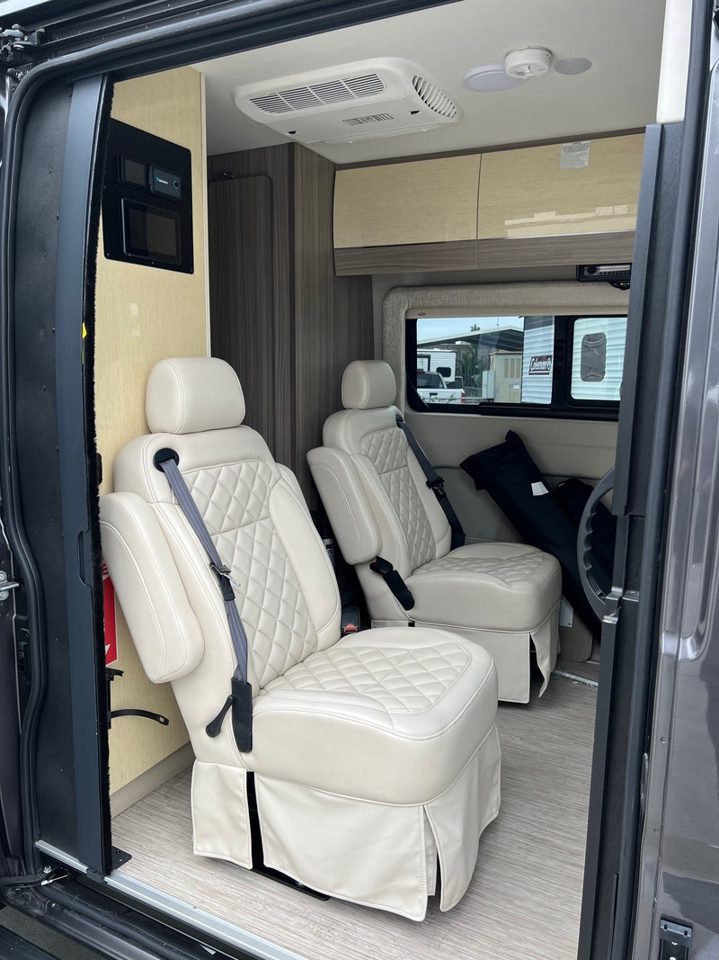 Luxury RV rental interior with cream captain's chairs, control panel, and overhead cabinets. — photo 5