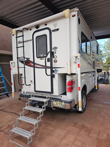  parked under cover. Ideal RV rental choice.|Rear of an Adventurer truck camper RV rental on a pickup