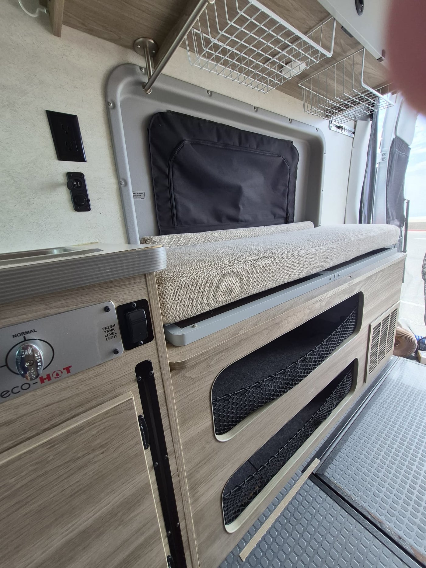  and a ladder leading to the upper sleeping area.|Compact RV rental bathroom featuring an integrated white shower — photo 19