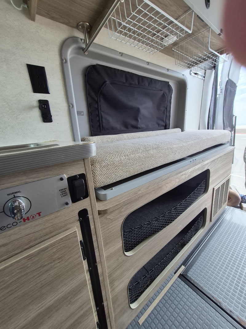  and a ladder leading to the upper sleeping area.|Compact RV rental bathroom featuring an integrated white shower — photo 19