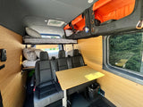 Experience comfort in this RV rental: bunk beds, rear seats, dining table, and overhead storage visible.