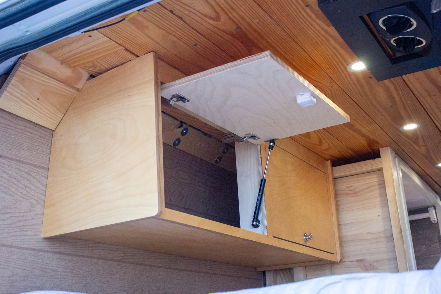 Overhead wood cabinets with gas struts offer smart storage in this rv rental.