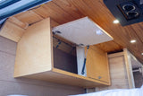 Overhead wood cabinets with gas struts offer smart storage in this rv rental.