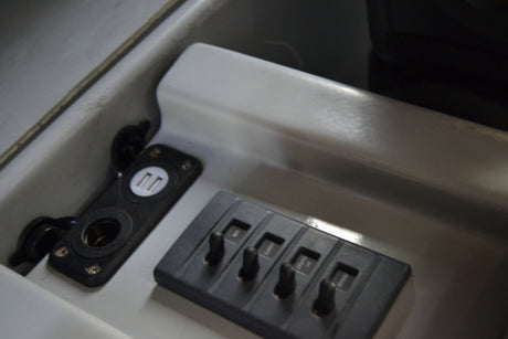 RV rental console showing USB/12V charging outlets & switches for USB, lights, DC, horn. Essential power options.
