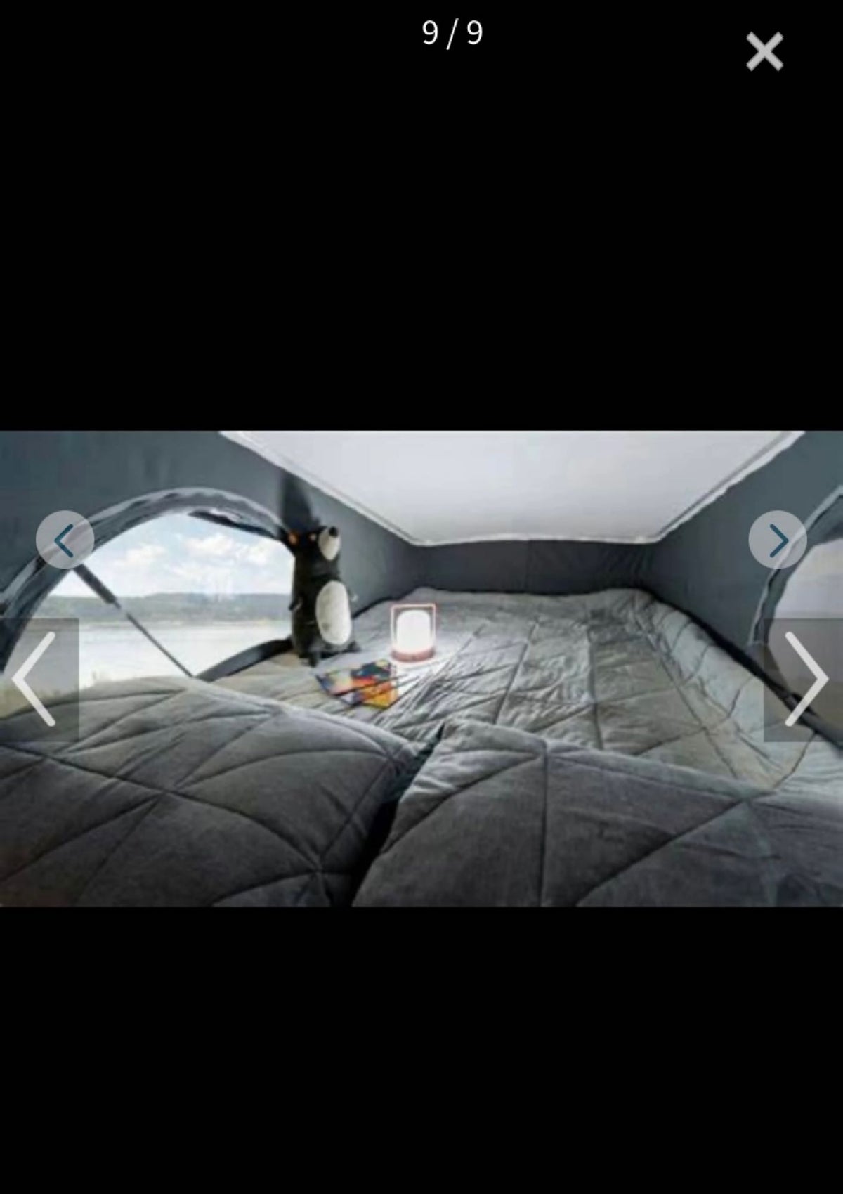 Cozy RV rental pop-top bedroom featuring a comfortable bed, a bright lantern, and a picturesque waterfront view. Perfect for camping! — photo 9