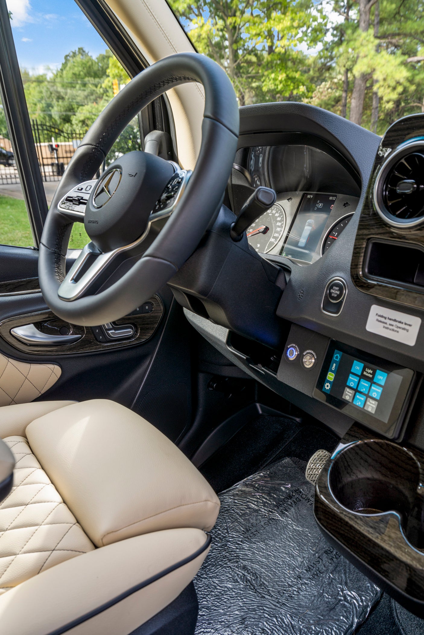 Luxurious RV rental driver's area: Mercedes-Benz dashboard with digital display, power controls, and quilted leather seats.