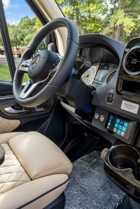 Luxurious RV rental driver's area: Mercedes-Benz dashboard with digital display, power controls, and quilted leather seats.