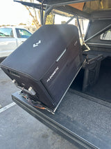 Mobile Dometic CFX fridge sliding out of a truck setup, great gear for an RV rental or overlanding journey.