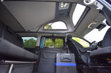 Spacious RV rental interior: pop-top bed, convertible rear seats/bed, and a portable cooler, ready for adventure.