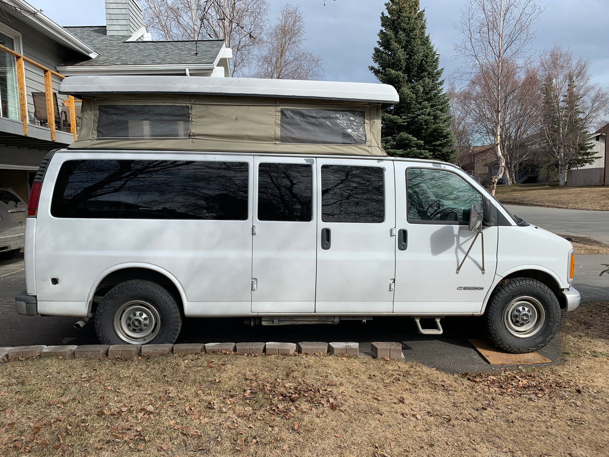 Side view of a white camper van with an extended pop-top tent. Great for an RV rental getaway. — photo 10