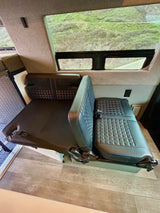 RV rental: Camper van interior with versatile seating that converts to a bed, offering scenic outdoor views.