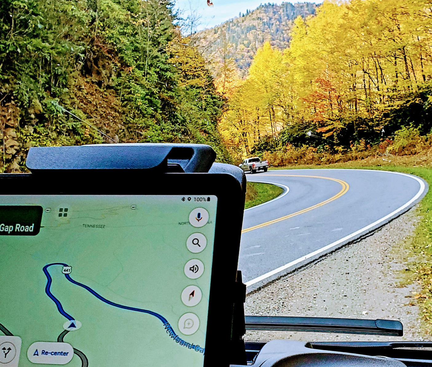 RV rental road trip: Navigating Newfound Gap Road 441 through vibrant autumn mountains with a GPS map displayed.