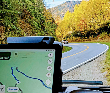 RV rental road trip: Navigating Newfound Gap Road 441 through vibrant autumn mountains with a GPS map displayed.