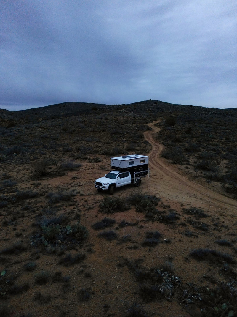  great for an rv rental adventure in arid hills.|White pickup truck with a pop-up camper — photo 2