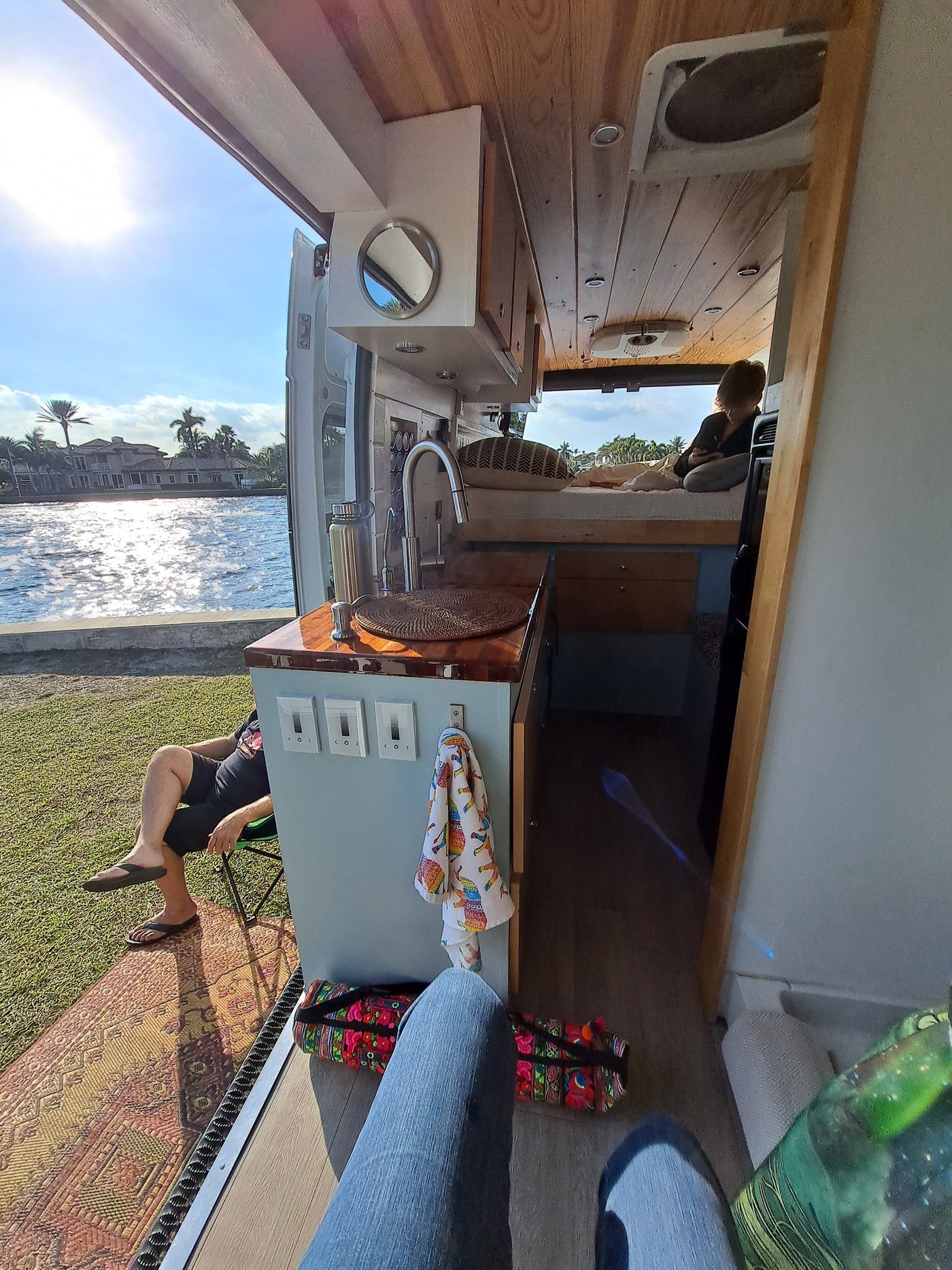 Enjoying a serene RV rental setup with the door open to a sunny waterfront view, blending indoor comfort with outdoor beauty. — photo 17