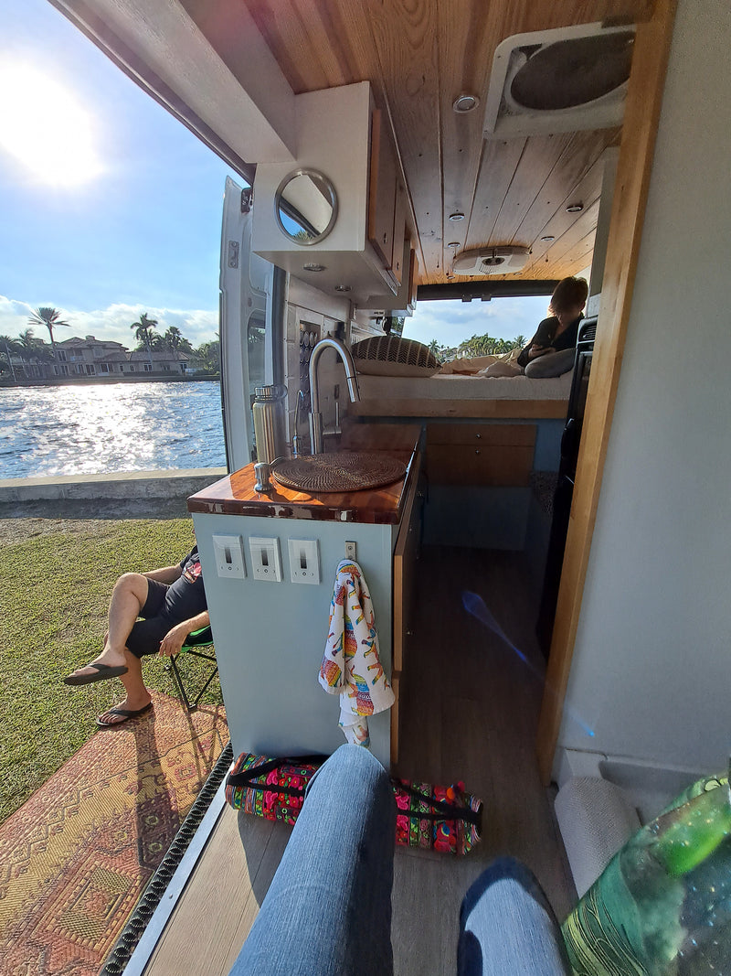 Enjoying a serene RV rental setup with the door open to a sunny waterfront view, blending indoor comfort with outdoor beauty. — photo 17