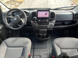 Inside a Ram van: a clear view of the dashboard, steering wheel, and infotainment system, often converted for rv rental use.