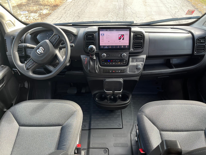 Inside a Ram van: a clear view of the dashboard, steering wheel, and infotainment system, often converted for rv rental use. — photo 19