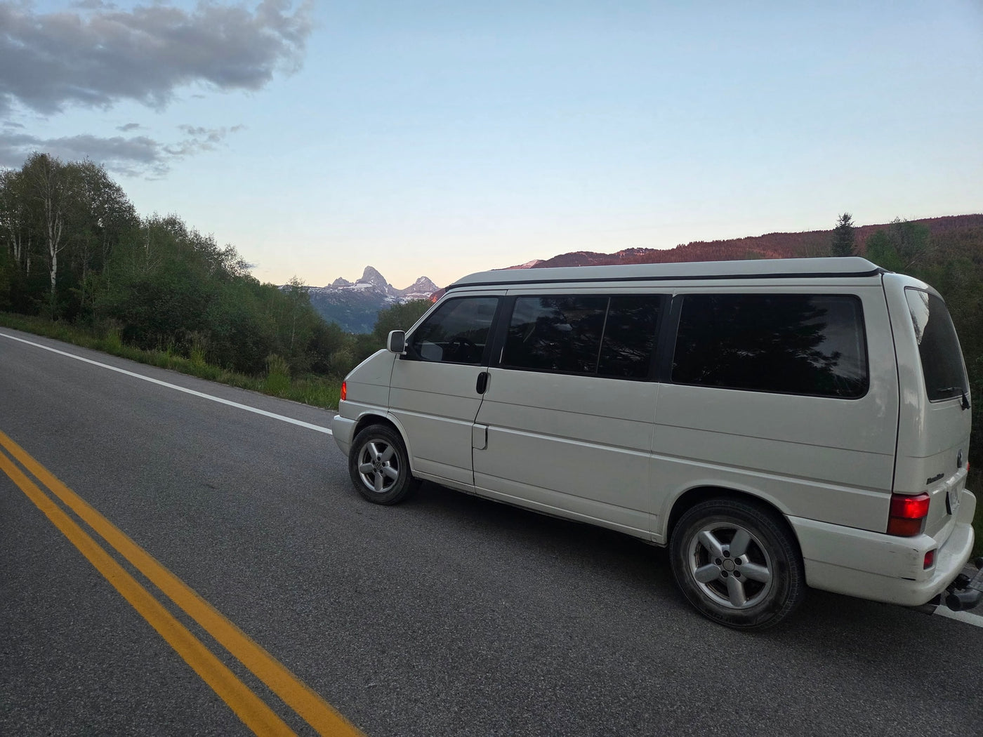 Scenic mountain drive with a white campervan, ideal as an RV rental for road trips, surrounded by nature and peaks. — photo 11