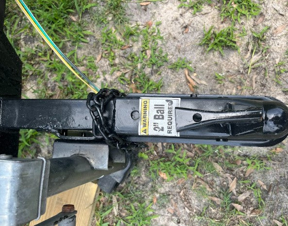 RV rental trailer hitch coupler showing warning for a 2" ball required & safety chain. Critical towing component.