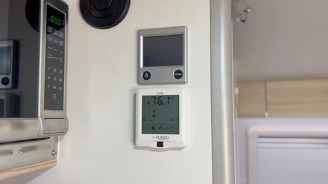 RV rental interior featuring a microwave and digital controls, including a thermostat set to 76.1°F, for comfort.