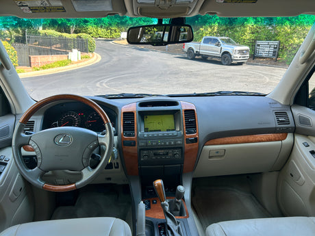 Lexus GX interior, dashboard with navigation. Road ahead with a truck. Consider an RV rental for future trips.