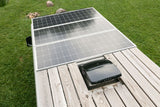 Overhead view of an RV roof, showcasing solar panels, a wooden deck, and a roof vent, ideal for an rv rental.