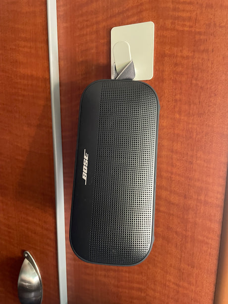 Stay entertained in your RV rental with this Bose portable speaker, conveniently hung on an adhesive hook on a wooden wall.