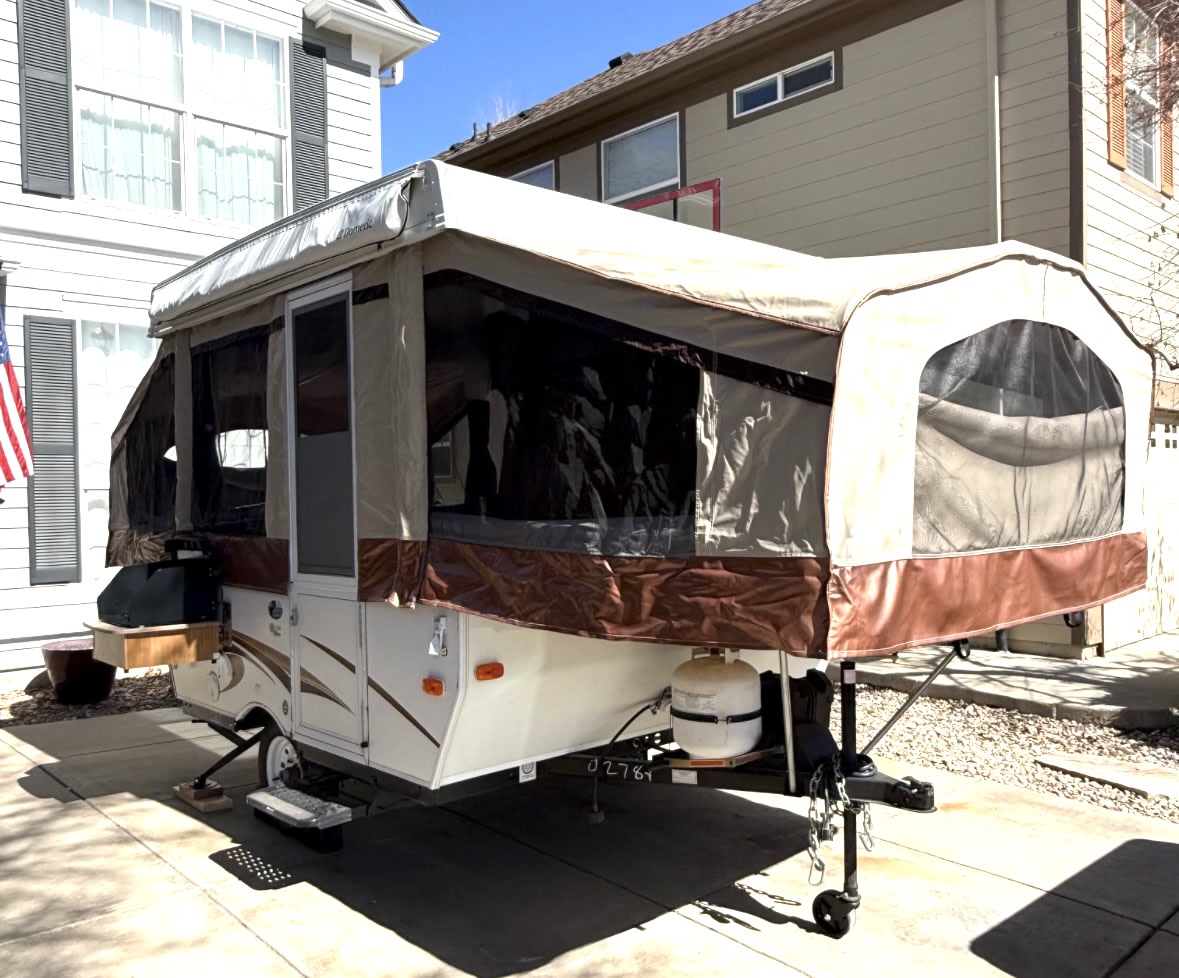 This pop-up camper, an RV rental, is fully set up with extended canvas & screens on a paved driveway. — photo 2