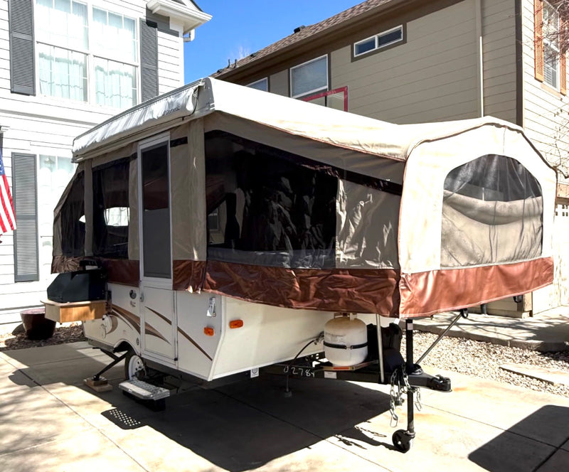 This pop-up camper, an RV rental, is fully set up with extended canvas & screens on a paved driveway. — photo 2