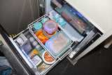Compact RV rental fridge drawer neatly organized with dairy-free yogurt, plant-based butter, milk, and prepared meals.