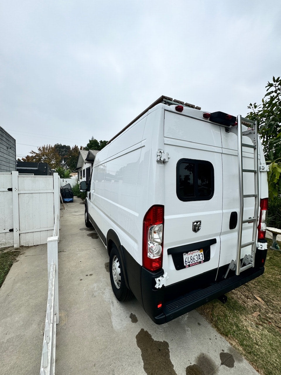 This white Ram Promaster RV rental, with rear ladder & roof rack, is ready for your next adventure.