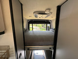 Spacious rv rental interior featuring a comfortable rear bed, AC, and smoke detector. Ready for adventure.