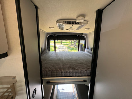 Spacious rv rental interior featuring a comfortable rear bed, AC, and smoke detector. Ready for adventure.