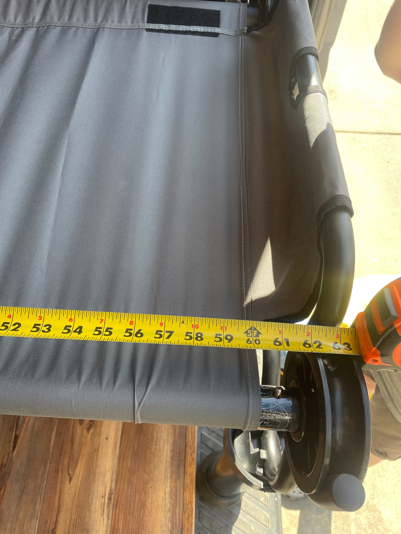 Measuring grey fabric component on an RV rental from 52 to 63 inches, revealing sturdy construction with black frame/wheels.