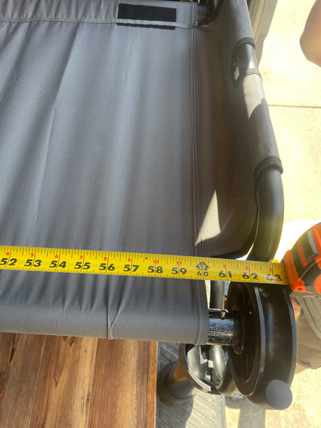Measuring grey fabric component on an RV rental from 52 to 63 inches, revealing sturdy construction with black frame/wheels.