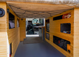 Inside an rv rental camper van: warm bamboo interior with practical storage, a flexible ceiling net, and a patterned floor.