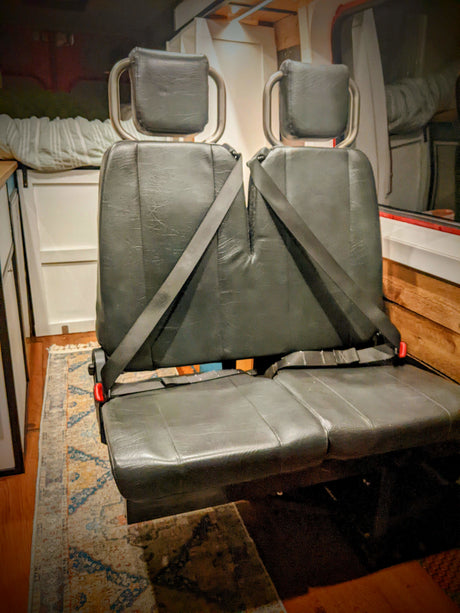 Dual black passenger seats with seatbelts in an RV rental, providing secure and flexible travel seating.