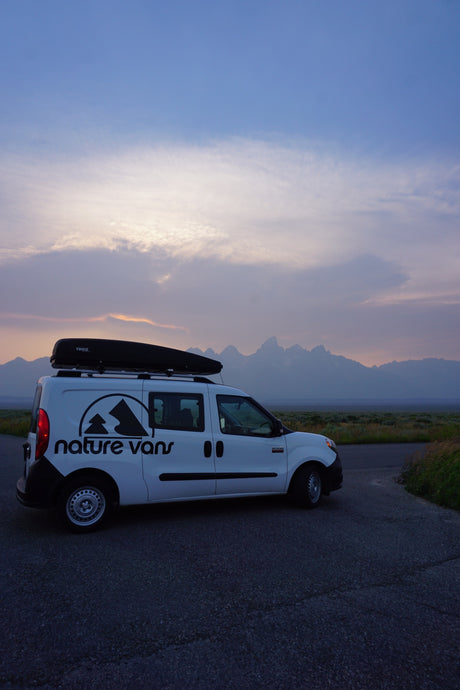 This Nature Vans rv rental van, with a Thule cargo box, is perfectly parked for a mountain sunset view.